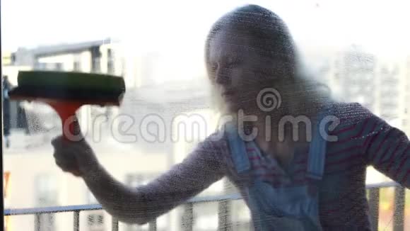 年轻女子擦窗动作缓慢视频的预览图