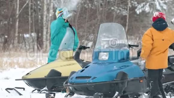 冬天一家人穿着五颜六色的衣服在雪地摩托中打雪球慢动作视频的预览图