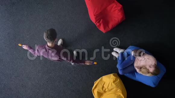 男子跳绳和女子打球的最高镜头坐在五颜六色的软包上视频的预览图