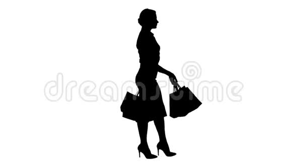 剪影快乐购物女人拿着五颜六色的购物袋走着视频的预览图