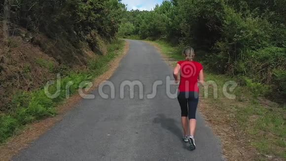年轻女子在森林里慢跑慢动作视频的预览图