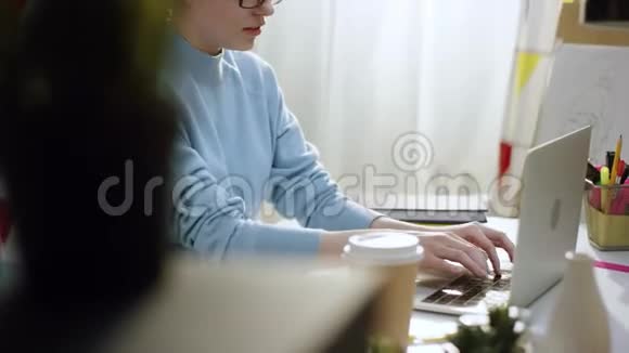 年轻女性自由职业者在笔记本电脑上写程序代码视频的预览图