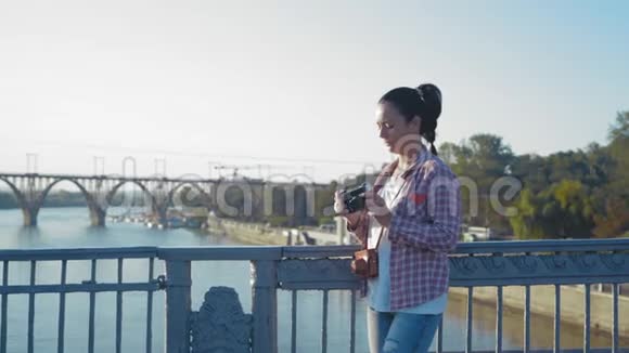 美丽的女人站在桥上拍电影视频的预览图