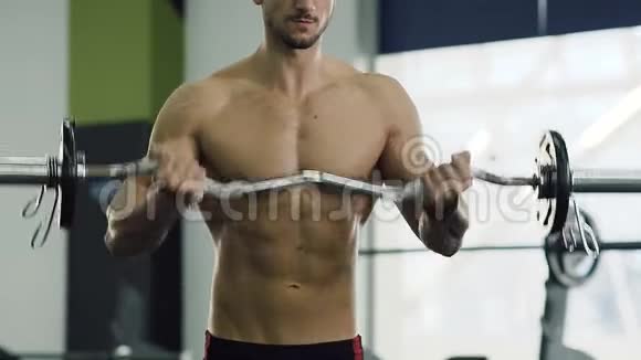 在健身房用杠铃做运动时男性躯干的特写镜头视频的预览图