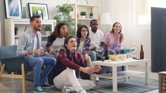 男人和女人的球迷在家里享受电视上的体育比赛笑着拥抱视频的预览图