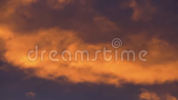夕阳下的金色云彩飘过紫罗兰色和紫色的雷云视频的预览图