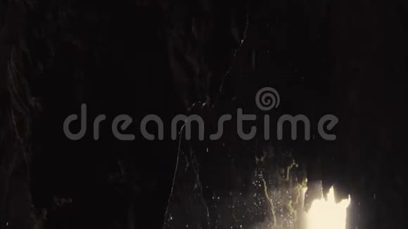 热带洞穴内部的慢速倾斜镜头水滴下落视频的预览图