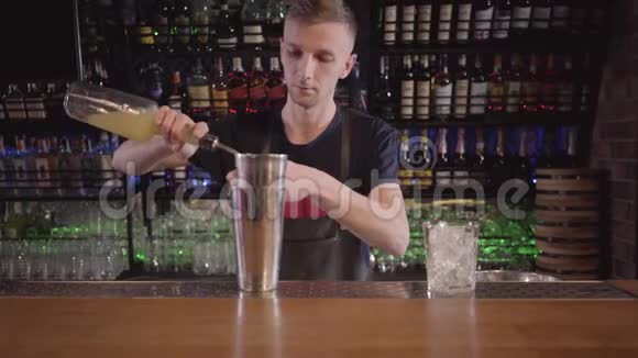 酒保混合学家使用摇床和制作酒精鸡尾酒与不同的饮料在美丽的现代酒吧关门视频的预览图