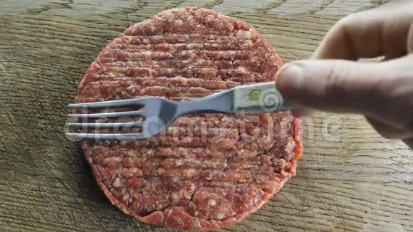 粗圆的切块放在一块木板上木板上用一个叉子叉起汉堡从上面拍摄视频的预览图