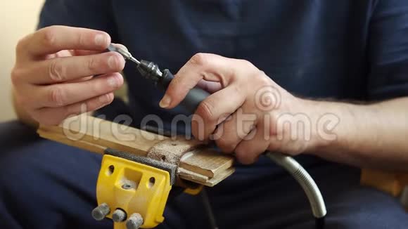 男性手使用旋转工具柔性轴从喇叭中雕刻出吉他挑子视频的预览图