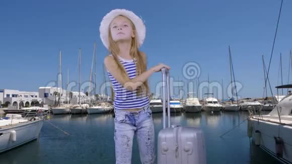 带旅行箱的旅游女孩游艇背景下的海港等待船视频的预览图
