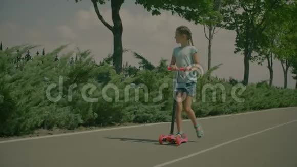 快乐的小女孩骑着踢踏板车视频的预览图
