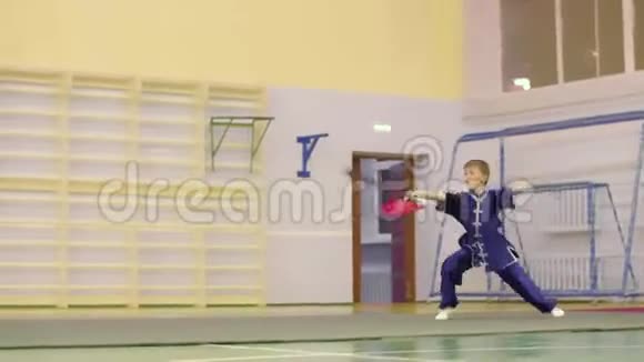 逸夫中国服饰中的小男孩用剑训练武术视频的预览图