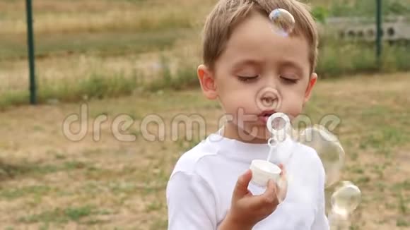 快乐的孩子吹肥皂泡特写气泡在风中缓慢地飞行视频的预览图