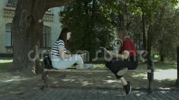 两个大学女生学习后在长凳上聊天视频的预览图