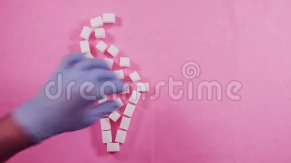 健康的人类牙齿在粉红色的背景上排列着精致的糖块龋齿的概念视频的预览图