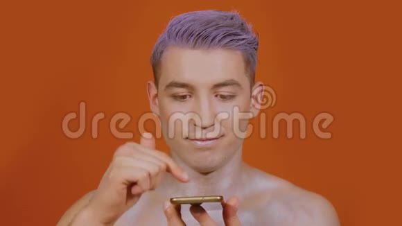 男人在橙色背景下使用手机视频的预览图
