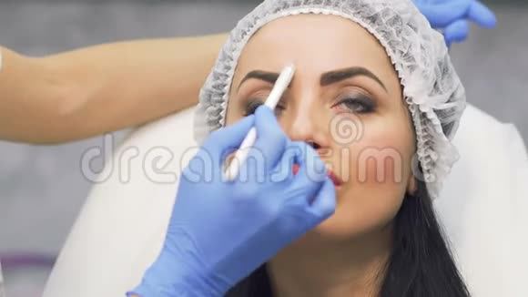 美容师为未来的肉毒杆菌手术绘制面部区域视频的预览图