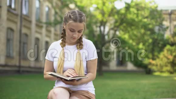 在大学花园集中青少年阅读书籍准备考试视频的预览图