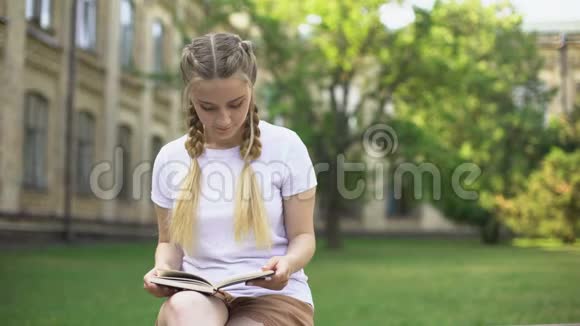 青少年阅读书籍时年轻人呈现田野花朵初恋调情视频的预览图