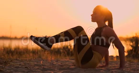 健身女人在海滩上做仰卧起坐健身妇女做仰卧起坐运动锻炼到海滩女性视频的预览图