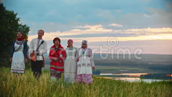 人们穿着传统的民间服装在田野上散步唱着一首歌视频的预览图
