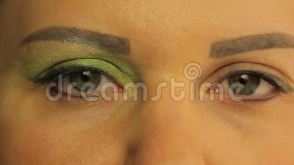 女性的眼睛一只眼睛染成了明亮的绿色阴影视频的预览图
