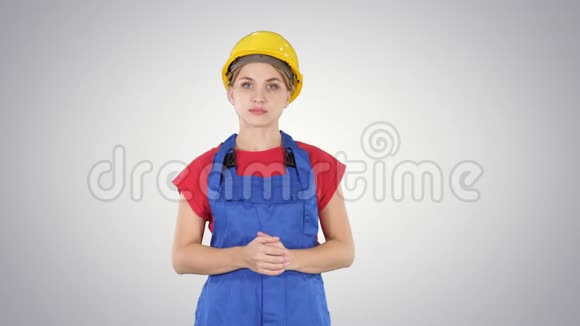 年轻的建筑工人妇女展示产品她的手从她的两侧梯度背景视频的预览图