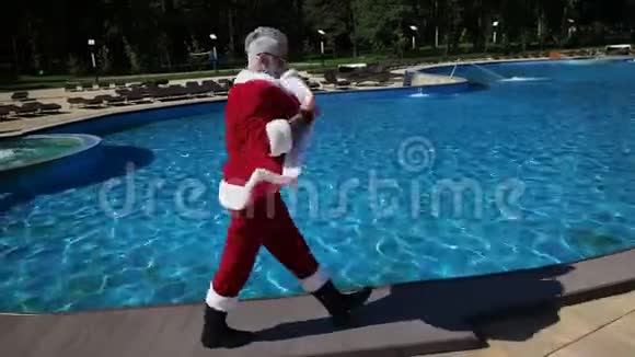 时尚圣诞老人在酒店游泳池里散步视频的预览图