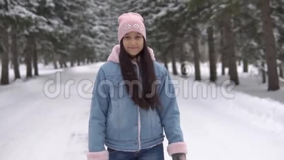 一个女孩走过一个冬天的森林身体很好在自己周围旋转慢动作视频的预览图