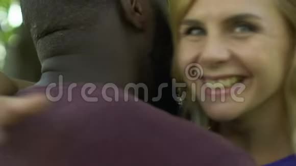 白人金发女人开心地笑着拥抱她的美国黑人男友视频的预览图