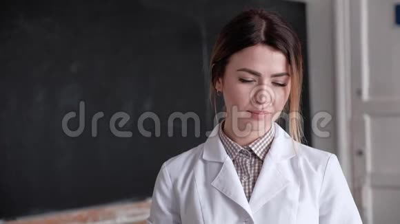 一个年轻女孩的肖像实验室助理穿着白色的医疗外套视频的预览图