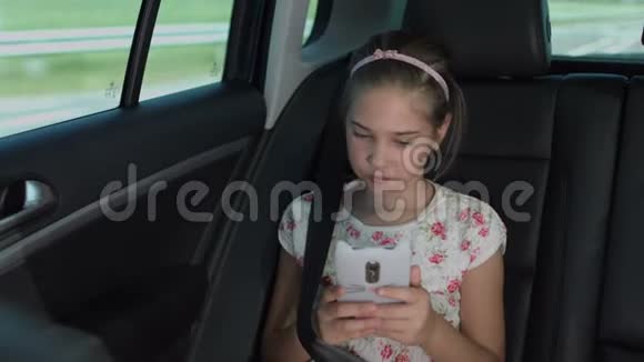 小女孩在车里用智能手机发短信视频的预览图