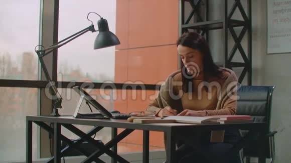 一位女平面设计师在一间有大窗户的办公室工作用手写笔和电脑触摸屏作画视频的预览图