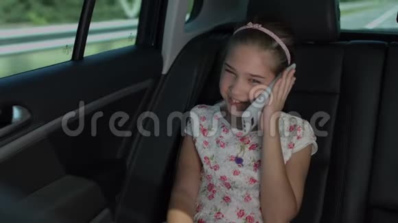 可爱的女孩在豪华车上用手机说话视频的预览图