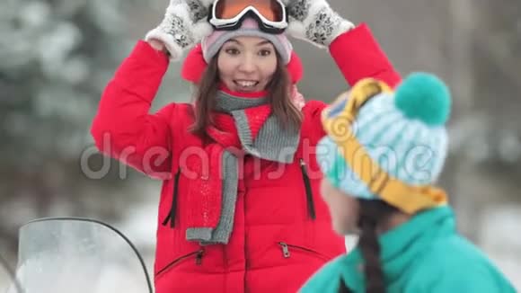 微笑的女人讲述一个有趣的故事在冬天的森林里戴着滑雪护目镜视频的预览图