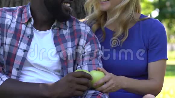 微笑混合种族夫妇展示绿色苹果健康的营养观念饮食视频的预览图