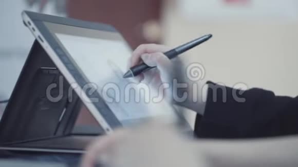 穿深色西装外套的人的特写用手写笔和数字平板电脑工作画一个女人库存数据视频的预览图