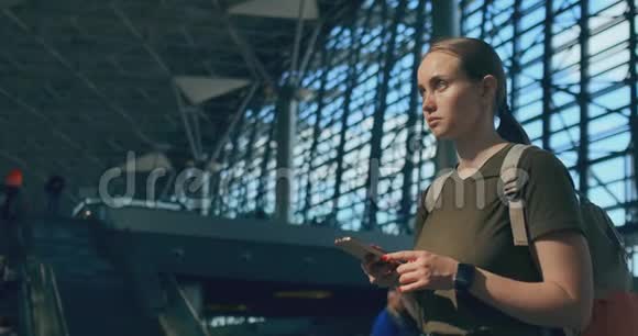女旅客在机场看记分牌出发寻找您的航班视频的预览图