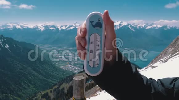 手拿着一个温度计在瑞士阿尔卑斯山的顶端罗瑟斯德纳伊视频的预览图