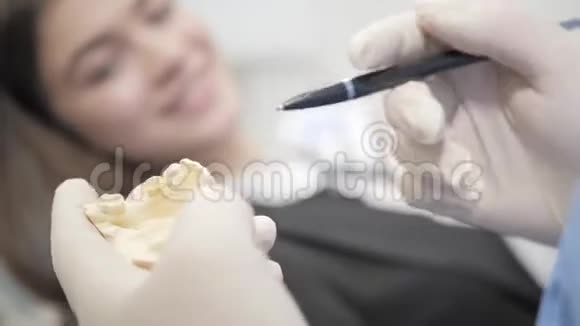 医生展示了下巴填充物和植入物牙科诊所牙医椅上年轻漂亮的女孩视频的预览图
