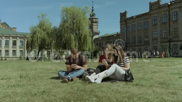 微笑着让学生在草坪上用智能手机联网视频的预览图