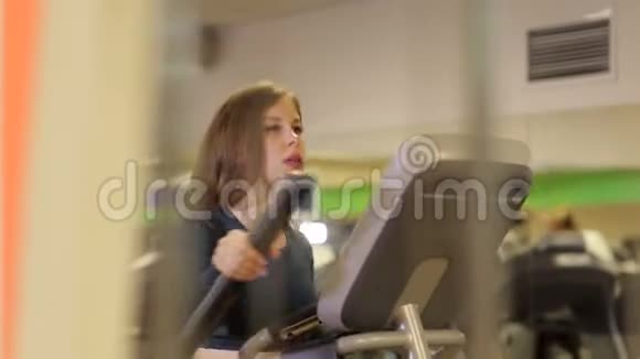 剧烈的有氧运动年轻的运动女孩在健身房的轨道上视频的预览图