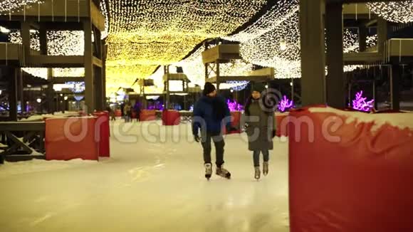 开溜冰场可爱的年轻夫妇一起滑冰一起玩得很开心视频的预览图