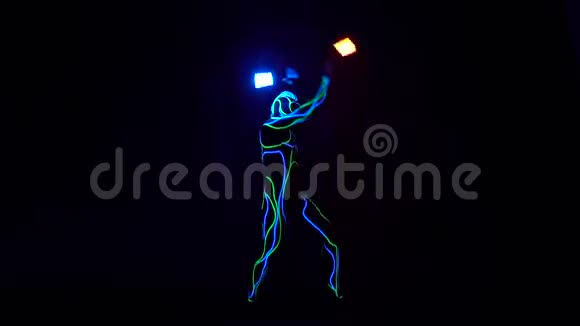 催眠的霓虹灯表演一个人站在黑暗中在锁链上旋转和摆动两盏灯视频的预览图