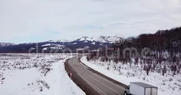 鸟瞰深冬乡村风景沿着荒芜的道路飞过视频的预览图