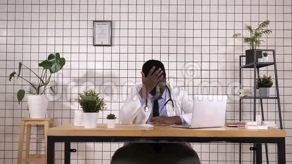 年轻的非裔美国医生因为疼痛和偏头痛而感到绝望和压力手放在头上视频的预览图
