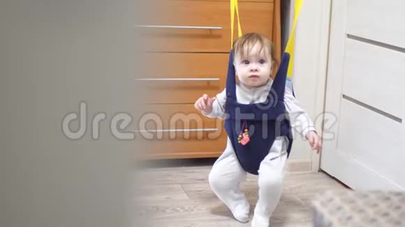 穿着工作服的小婴儿在儿童房玩跳跃游戏视频的预览图