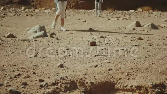 一群游客在炎热的沙漠中沿着岩石峡谷散步沙漠岩石背景埃及西奈慢运动4k视频的预览图