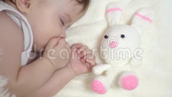 小宝宝睡在婴儿床上抱着玩具兔子视频的预览图